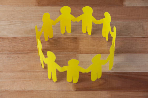 istock Paper cut outs forming a circle on wooden background 653111746