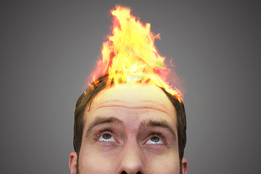 Surreal photo of a fire spreading on a man's head.