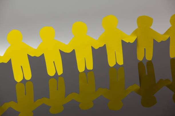 istock Paper cut outs forming a human chain 653115948
