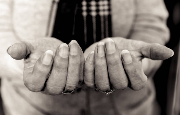 istock Elderly lady's hands in begging gesture. Black and white. 653116034