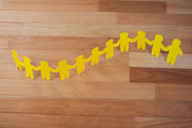 istock Paper cut outs forming a human chain 653116298