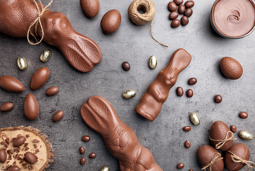 Delicious chocolate Easter bunny and eggs on rustic background