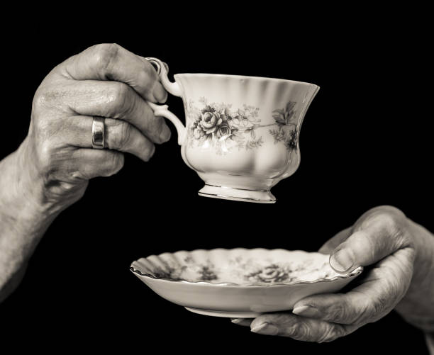istock Traditional teacup and saucer held in elderly woman's hands. 653117250