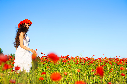 Young happy smiling woman in poppy field