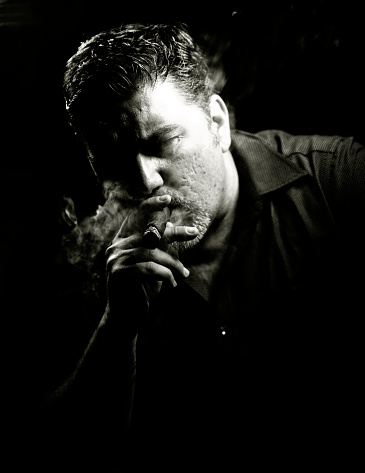 Cuban man smoking a cigar in the evening.