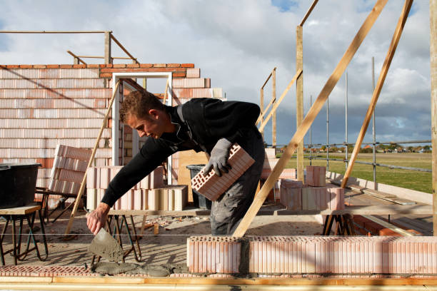 junge maurer maurer, mörtel auf einer wand in der sonne - mason brick bricklayer installing stock-fotos und bilder