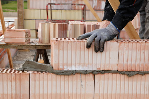 istock closeup of bricklayers hand with glove placing a stone 653124374