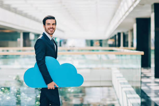istock Smiling businessman carrying a big blue cloud 653126656