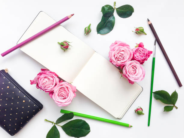 istock Colorful composition with sketchbook, roses and pencils. Flat lay 653127392