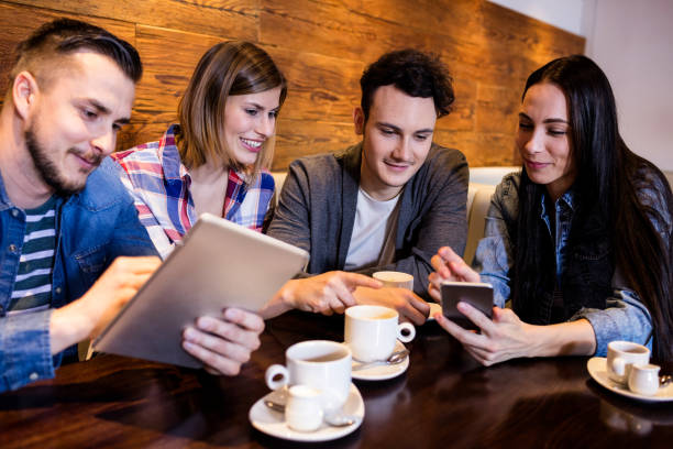 istock Friends with digital tablet and mobile phone at restaurant 653127730