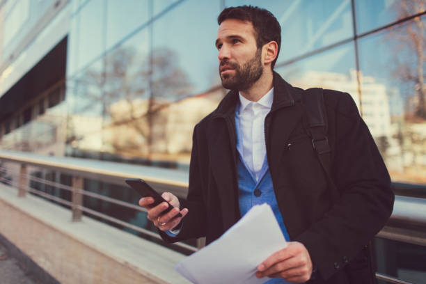 istock Businessman using smart phone outdoors 653134808