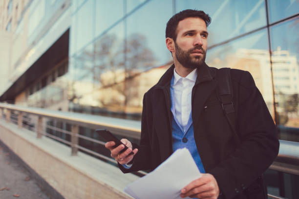 istock Businessman using smart phone outdoors 653135014