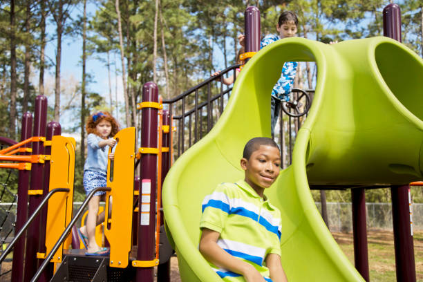 istock Multi-ethnic elementary school children playing on playground at park. 653141360