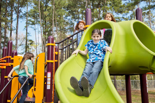 istock Multi-ethnic elementary school children playing on playground at park. 653141828