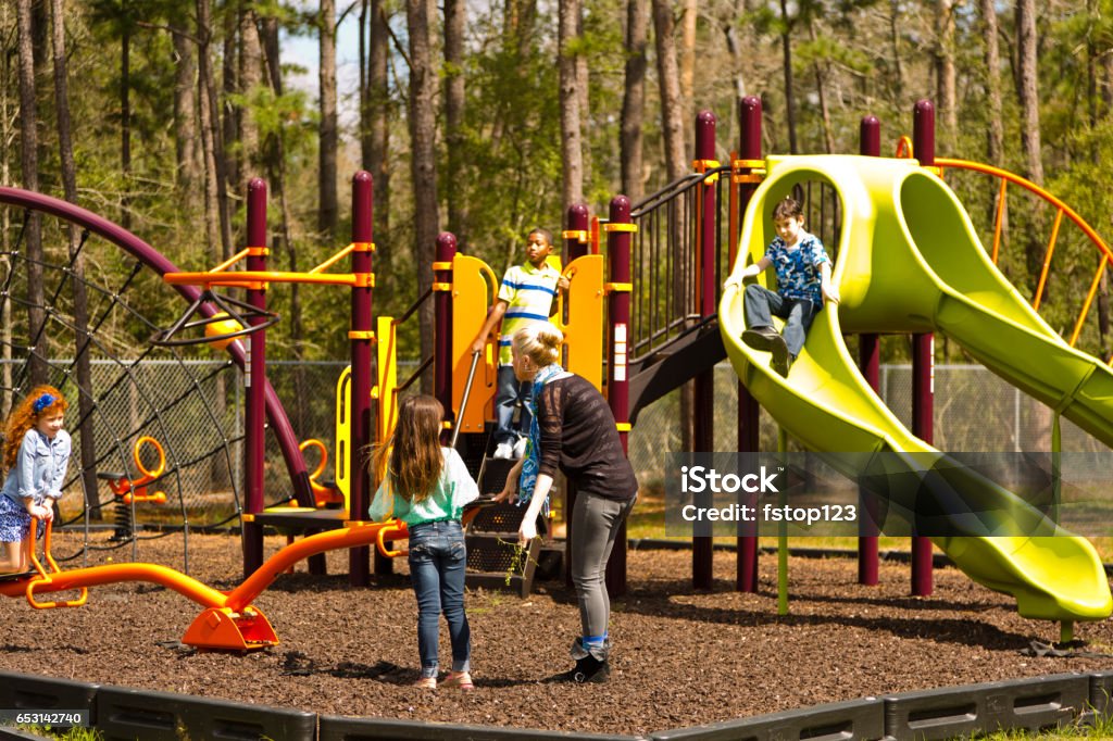 Escola multi-étnica crianças brincando no parque no parque. - Foto de stock de Parque infantil royalty-free