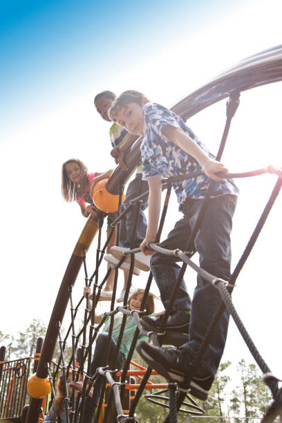 istock Multi-ethnic elementary school children playing on playground at park. 653146134