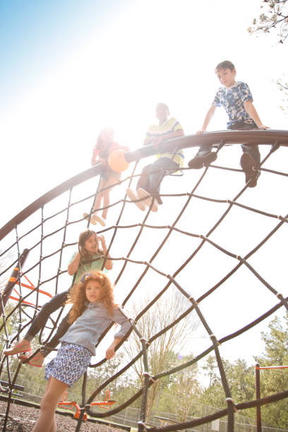 istock Multi-ethnic elementary school children playing on playground at park. 653151136