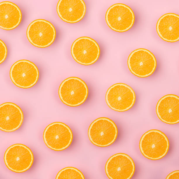 istock Colorful fruit pattern of fresh orange slices on pink background 653151378