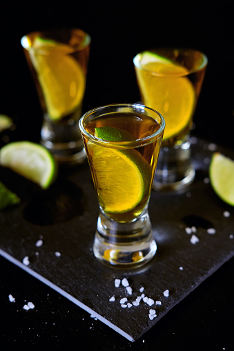 Strong alcohol drinks. Tequila glass shots in the bar with salt and lime slices.