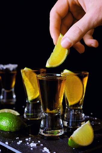 Strong alcohol drinks. Tequila glass shots in the bar with salt and lime slices.