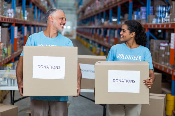 istock Smiling two volunteers holding a donations box 653159238
