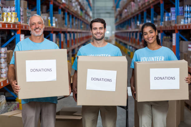 istock Portrait of three volunteers holding a donations box 653159332