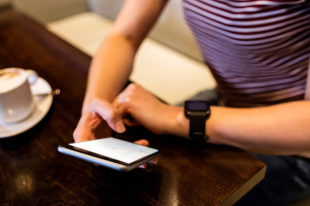 istock Woman using smartphone at table in restaurant 653159670