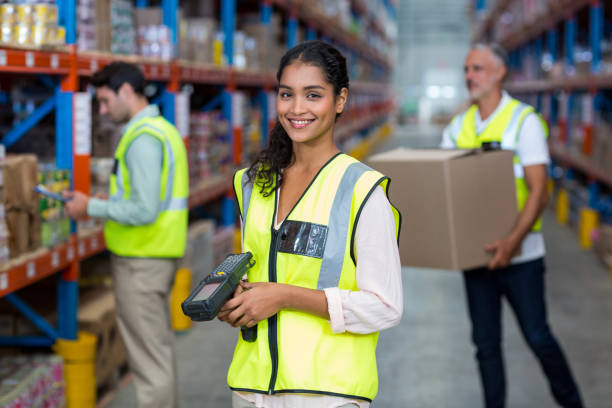 portrait of female warehouse worker standing with barcode scanner - warehouse worker imagens e fotografias de stock