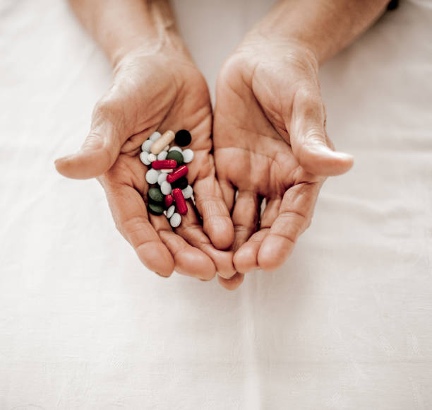 istock Old Hands Taking Medicine - Close Up 653160996
