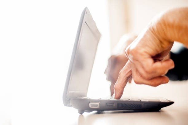 Senior Woman Determined To Use Computer - Close Up Hands