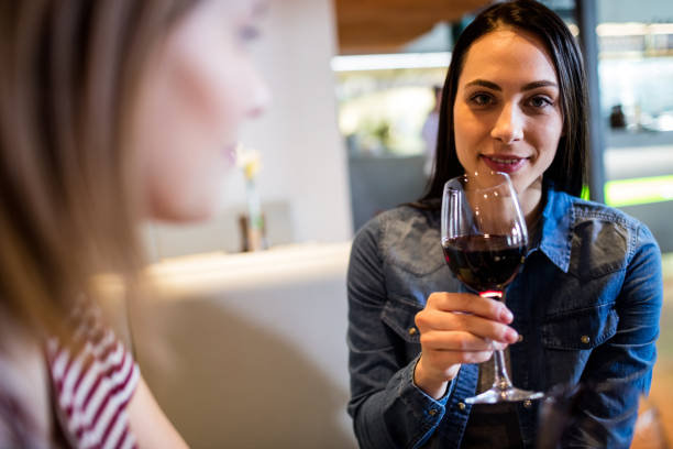 istock Beautiful woman drinking wine with friend 653166896