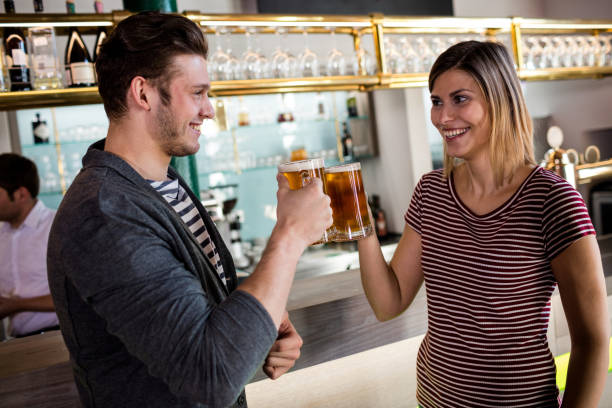 istock Young couple toasting beer mug by counter 653171698