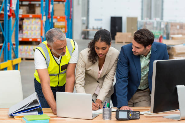 Warehouse managers and worker discussing with laptop Warehouse managers and worker discussing with laptop in warehouse office warehouse office stock pictures, royalty-free photos & images