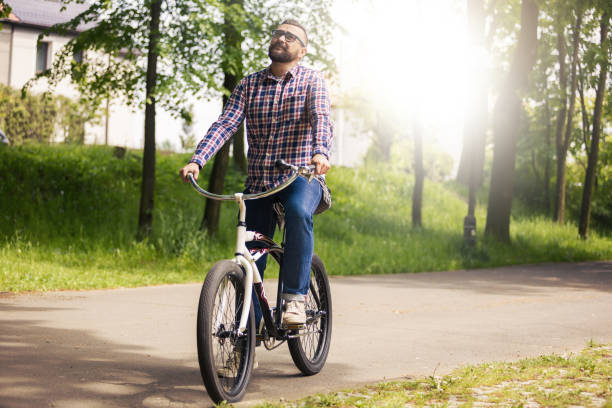 istock Young modern man riding bike in park thinking 653177930