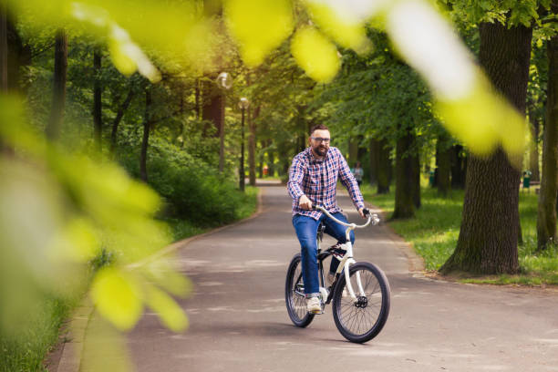 istock Young man riding bike through the park 653178024