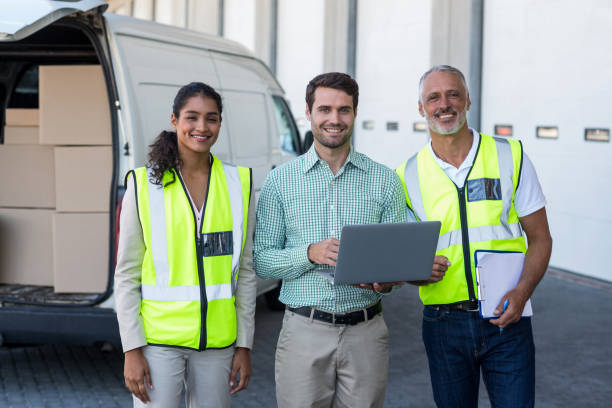 istock Manager and warehouse workers standing with laptop and clipboard 653178170
