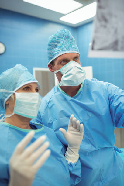 istock Male and female surgeons interacting in operation theater 653178190
