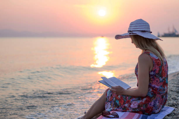 istock Young women reading on beach 653188178