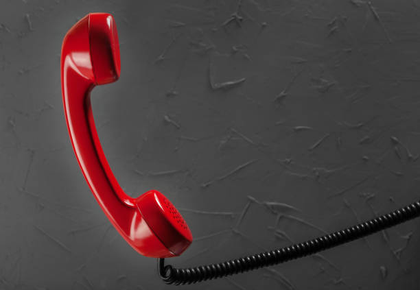 istock landline red phone on a gray wall background 653188316