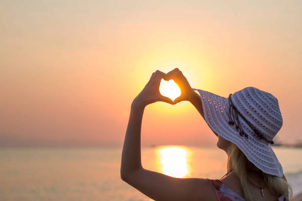 istock Young women making heart shape on beach 653188418