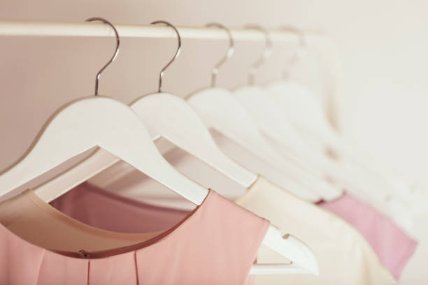 vêtements pour femmes dans des tons roses sur un cintre blanc. - clothing closet hanger dress photos et images de collection