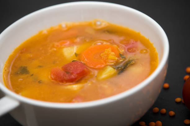 istock close up on soup with tomato, lentil and potato, rustical background, top view 653199146