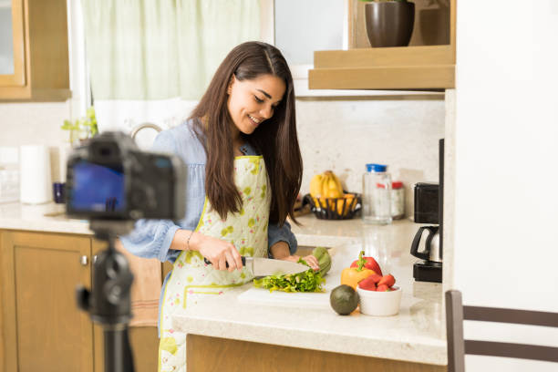 istock Cute woman recording food vlog 653201196