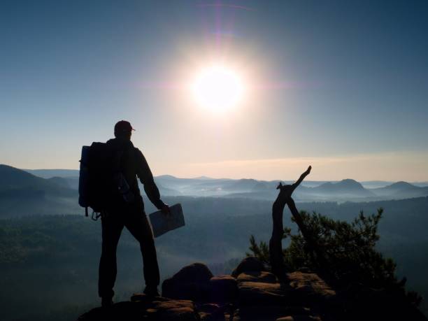 istock Tall tourist guide looking in paper  map. Wild hilly nature 653204920