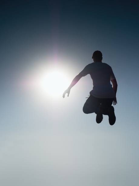 istock Man fly in air. Blue  Toned effect. Man falling down with hands up. 653205338