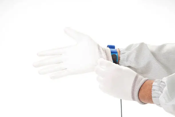 Photo of Bracelet on the hand of a man wearing ESD cloth and  glove static resistance (ESD) bracelet or ground equipment, anti-static, used to safely ground is working. electronic devices