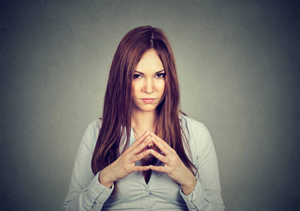 istock sneaky, sly, scheming young woman 653211828