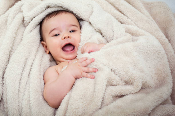 istock Cute baby boy in bed under a fluffy blanket 653214822