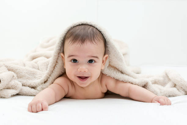 istock Cute baby boy in bed under a fluffy blanket 653214920