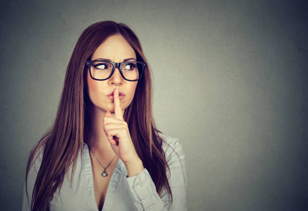 istock Woman saying hush be quiet with finger on lips gesture 653215110